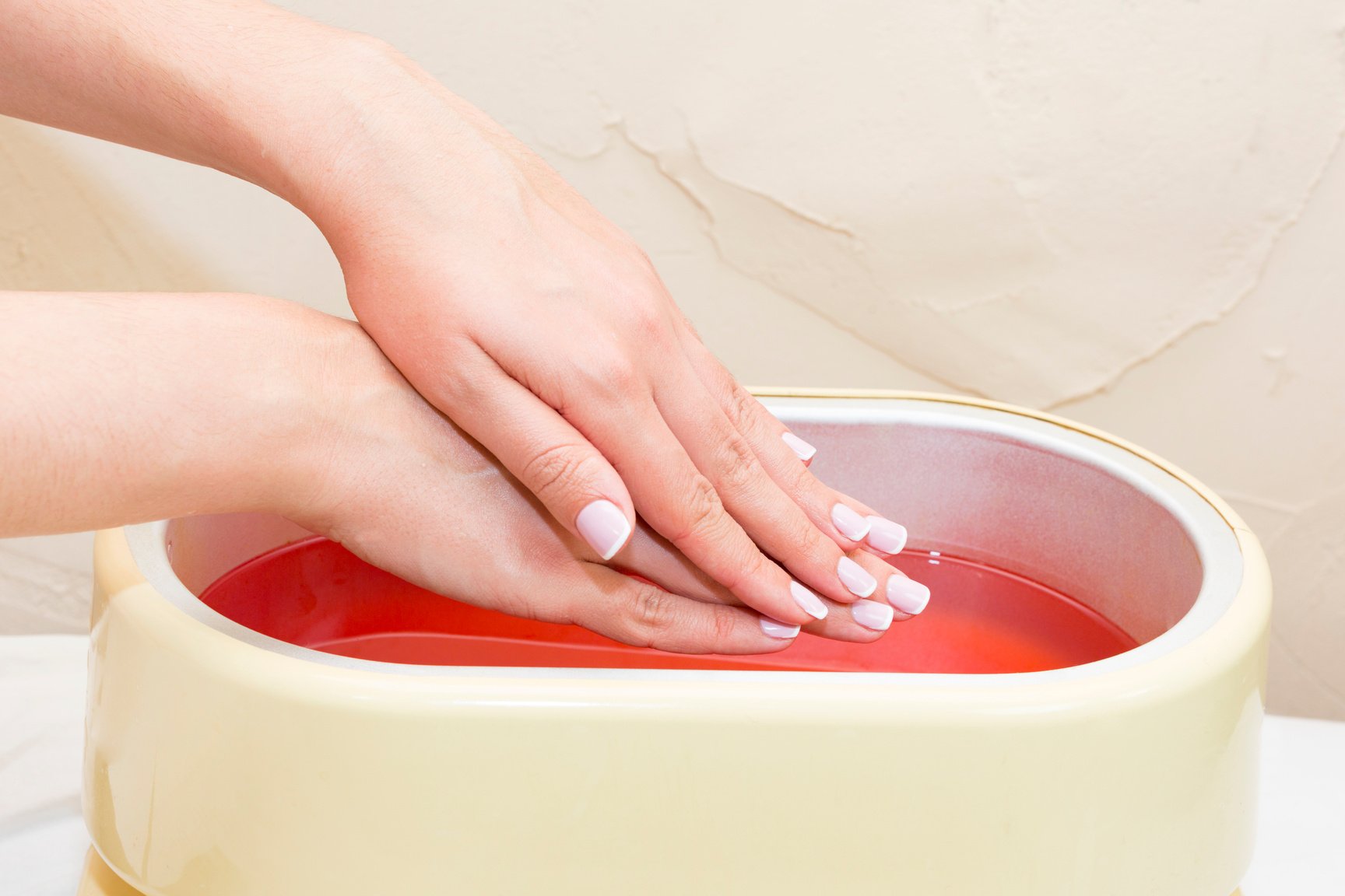 The process of paraffin therapy of a female hand is shot close up